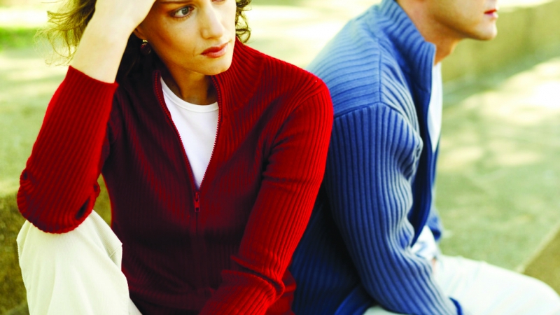 Young Couple Seated Back To Back