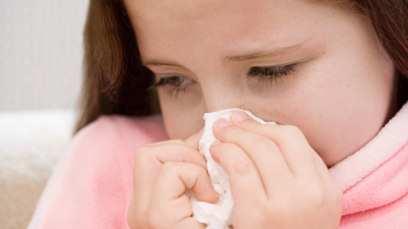 Girl blowing her nose